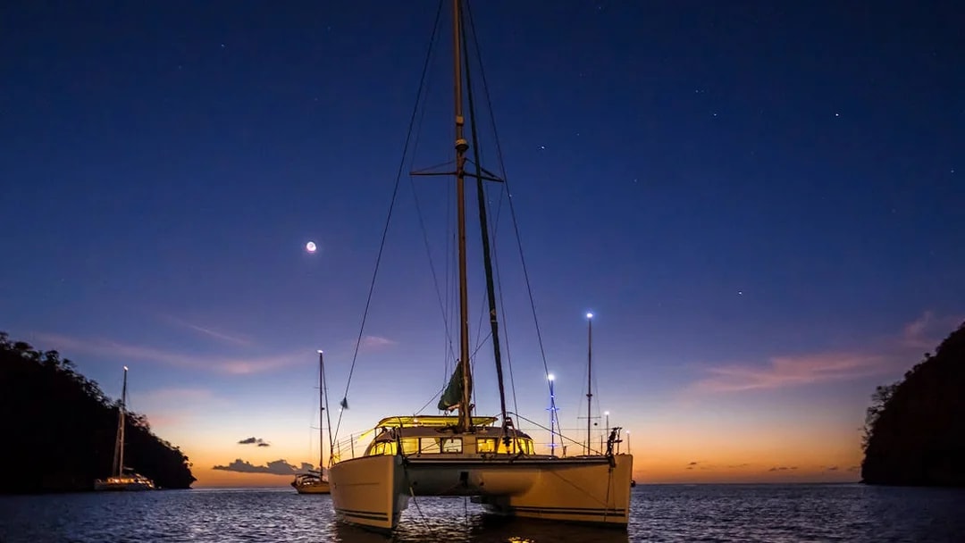 Catamaran sailing at sunset during a 2-hour night cruise in Lisbon.