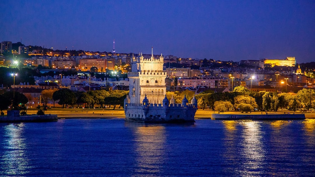 Belem Tower illuminated at night during a Lisbon cruise.