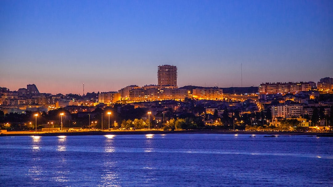 Lisbon cityscape at dusk viewed from a night cruise on the Tagus River.
