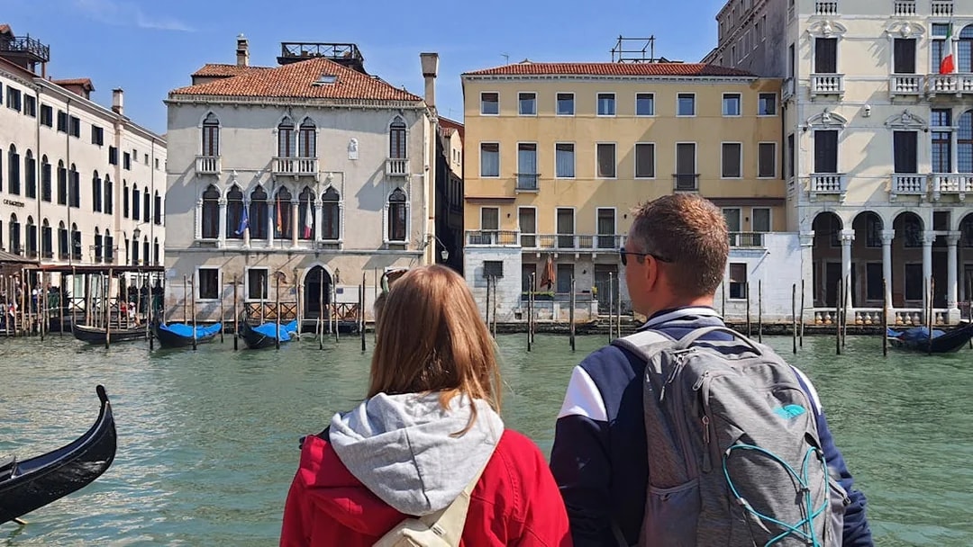 Tourists viewing Venetian architecture from a canal during a small group tour in Venice.