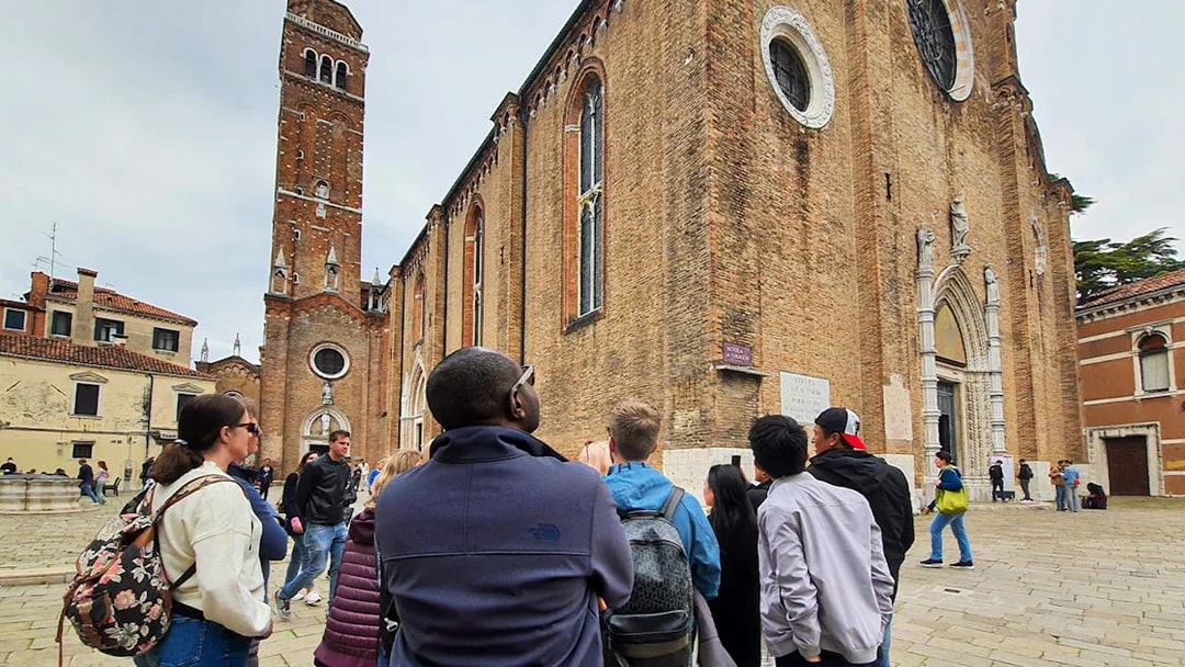 Tour group exploring Basilica dei Frari in Venice.