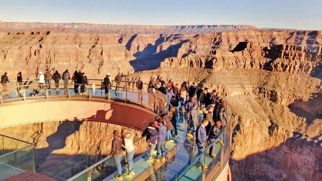 Visitors on the Skywalk bridge overlooking the Grand Canyon during a West Airplane Tour.
