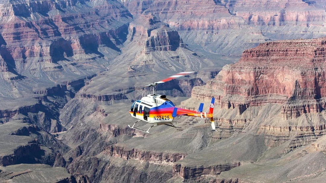 Helicopter flying over the Grand Canyon's vast rock formations.