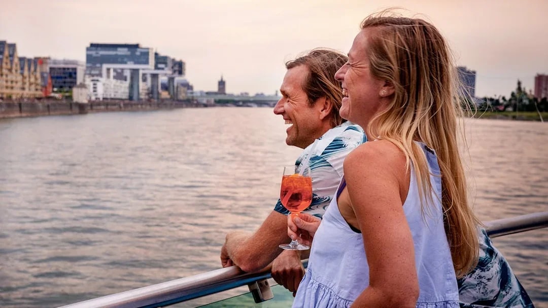 Couple enjoying a sunset view on a Cologne evening panorama cruise.