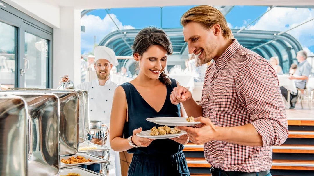 Couple enjoying buffet on Prague lunch cruise with live music.