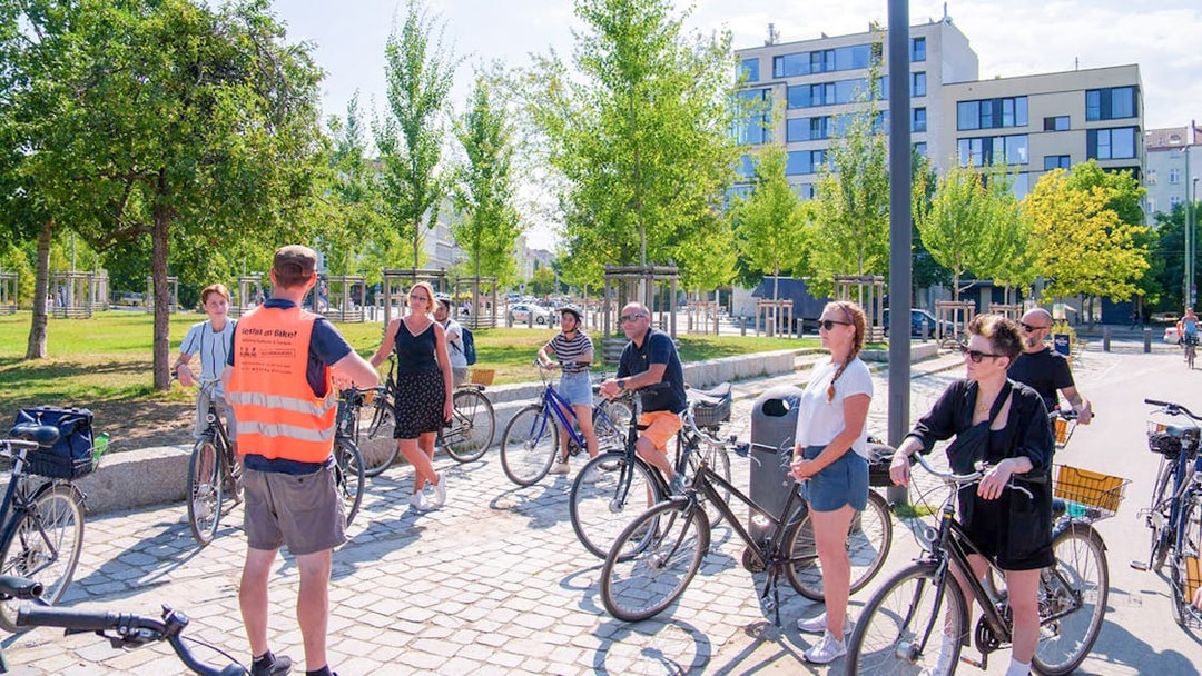 Group of cyclists listening to a guide during a Berlin Wall bike tour.