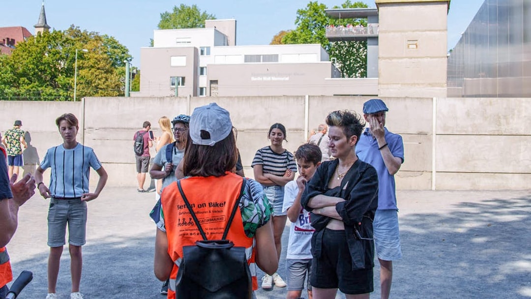Group of tourists listening to a guide during a Berlin Wall bike tour.