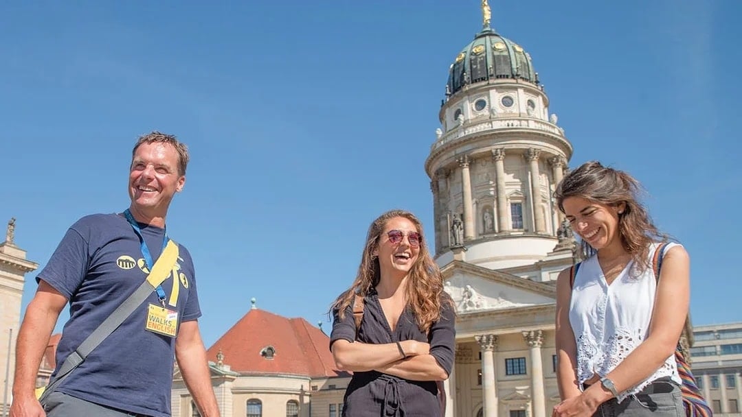 Tour group in front of Berlin's French Cathedral on a sunny day.
