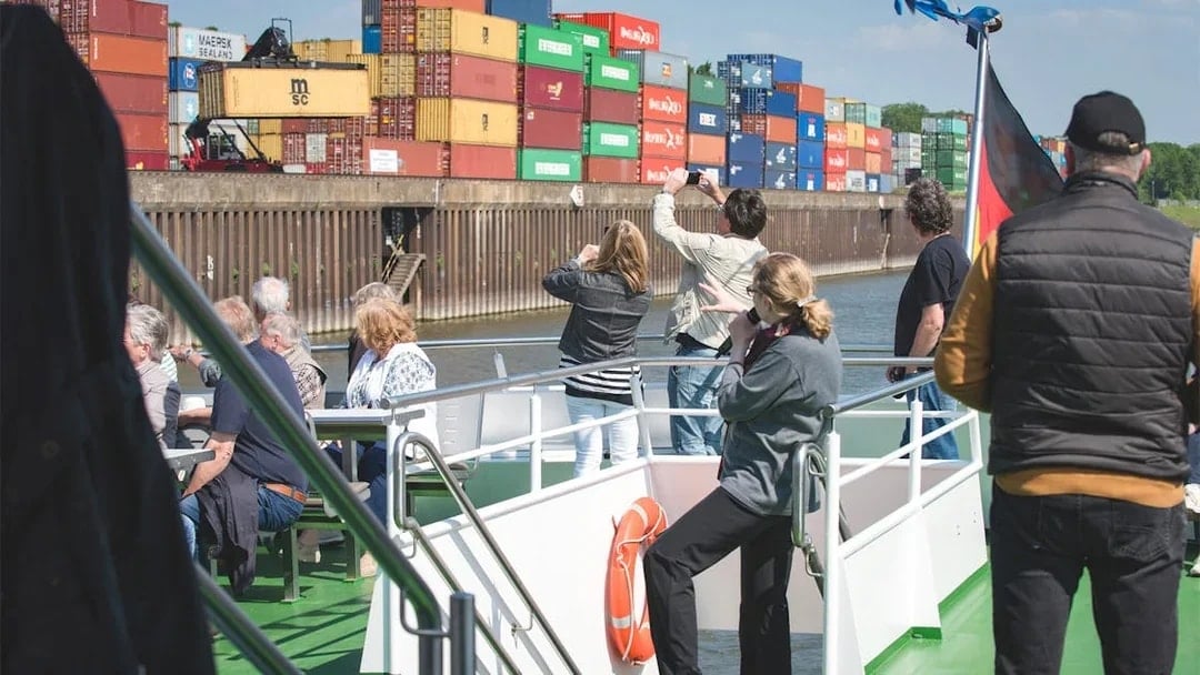 Tourists on a boat viewing shipping containers at Cologne Harbour.