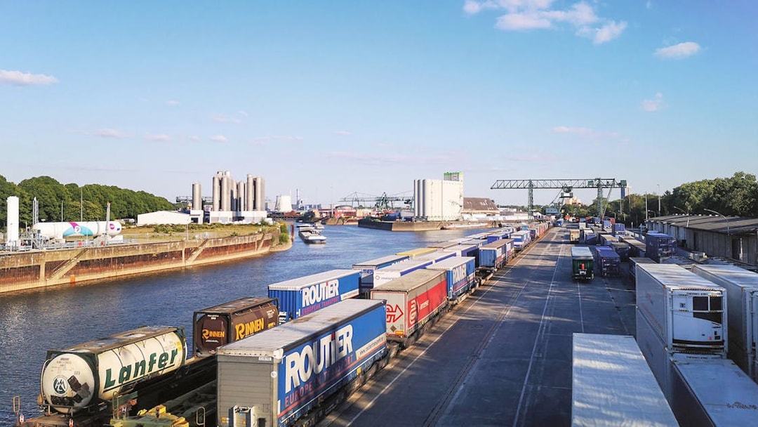 Cargo containers and cranes at Cologne Harbour, Germany, with a river view.