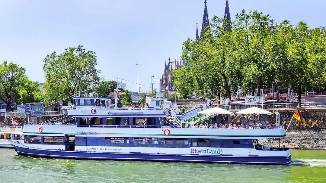 Harbor cruise boat on the Rhine River with Cologne Cathedral in the background.