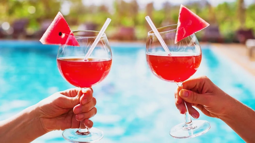 Tourists holding drinks by the thermal pool at Therme Bucuresti Spa, Bucharest.
