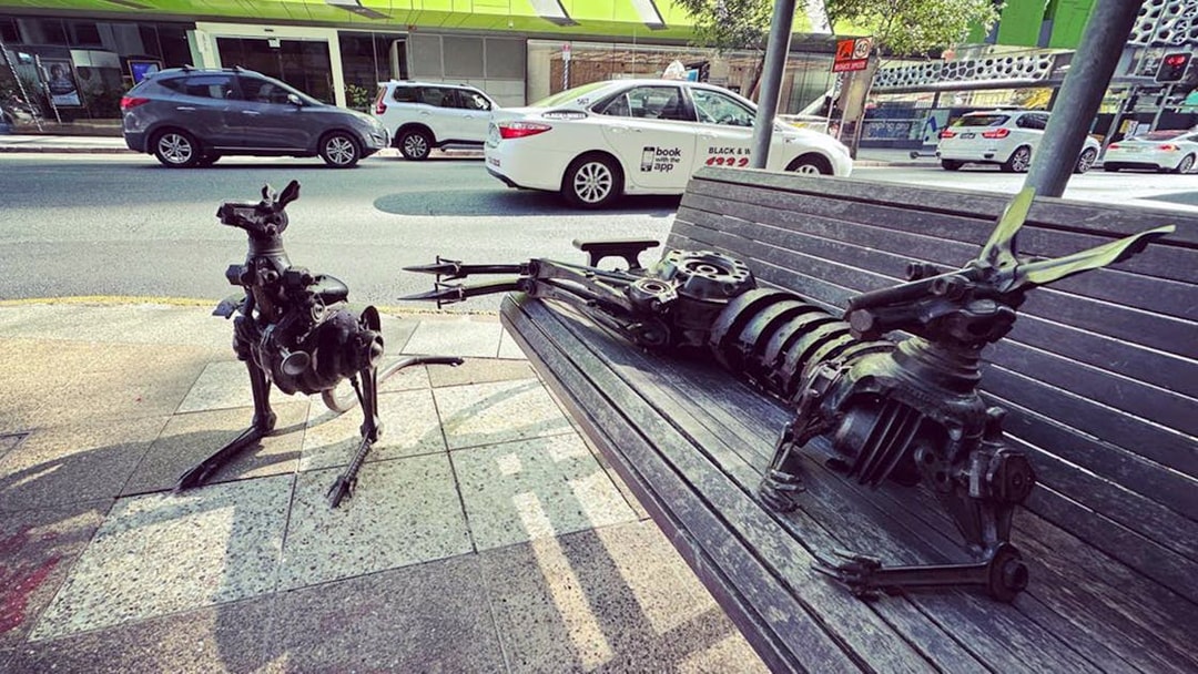 Metal kangaroo sculptures on a bench in Brisbane city street.