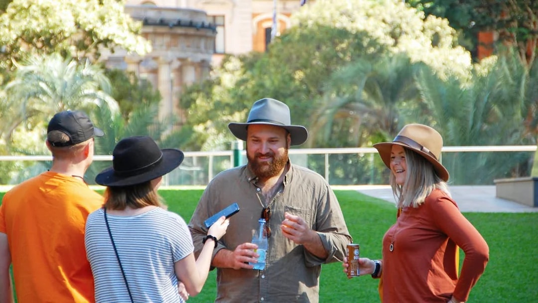 Group enjoying a walking tour in Brisbane with historic architecture in the background.