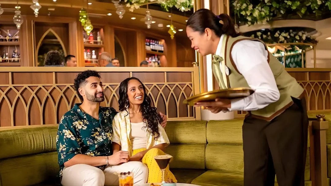 Couple enjoying drinks at Tianas Bayou Lounge on Disney Adventure Cruise.