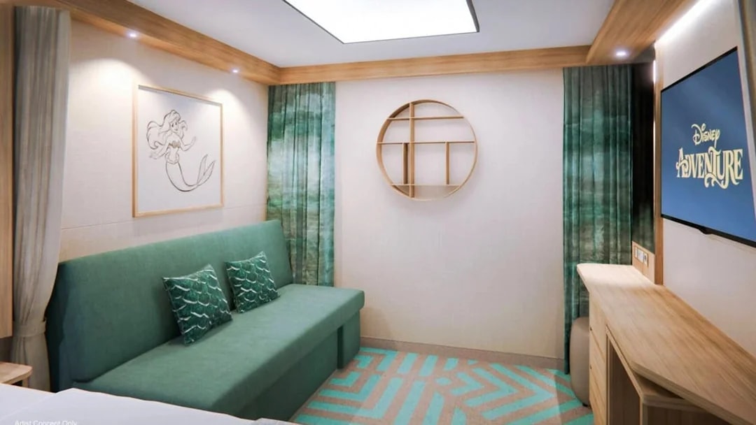 Deluxe Inside Stateroom on Disney Adventure Cruise with sofa, artwork, and TV.