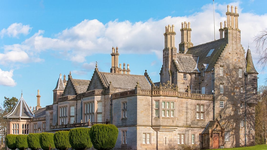 Historic mansion with ornate chimneys and manicured gardens, part of The Grande Ticket tour.