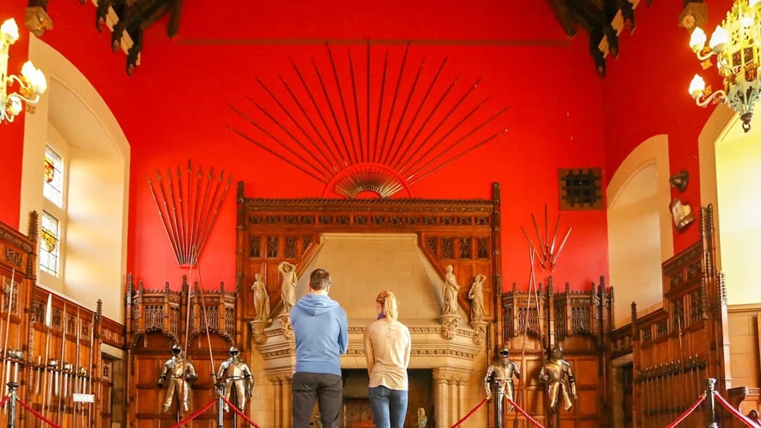 Visitors observing the Great Hall's medieval armor display inside Edinburgh Castle.