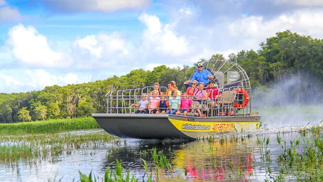 Guests on an airboat tour enjoying the Everglades view.