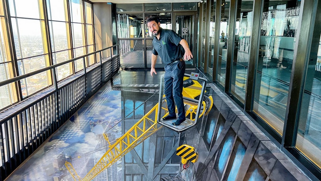 Man standing on a 3D art crane at Chicago 360 Observation Deck.