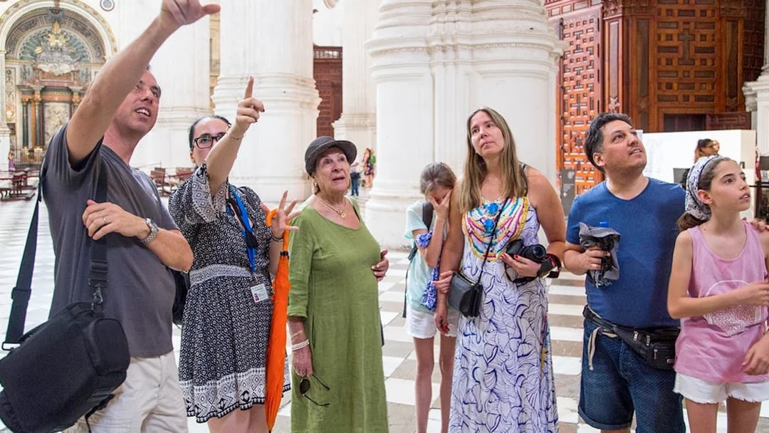 Group of tourists inside Granada Cathedral during guided tour.