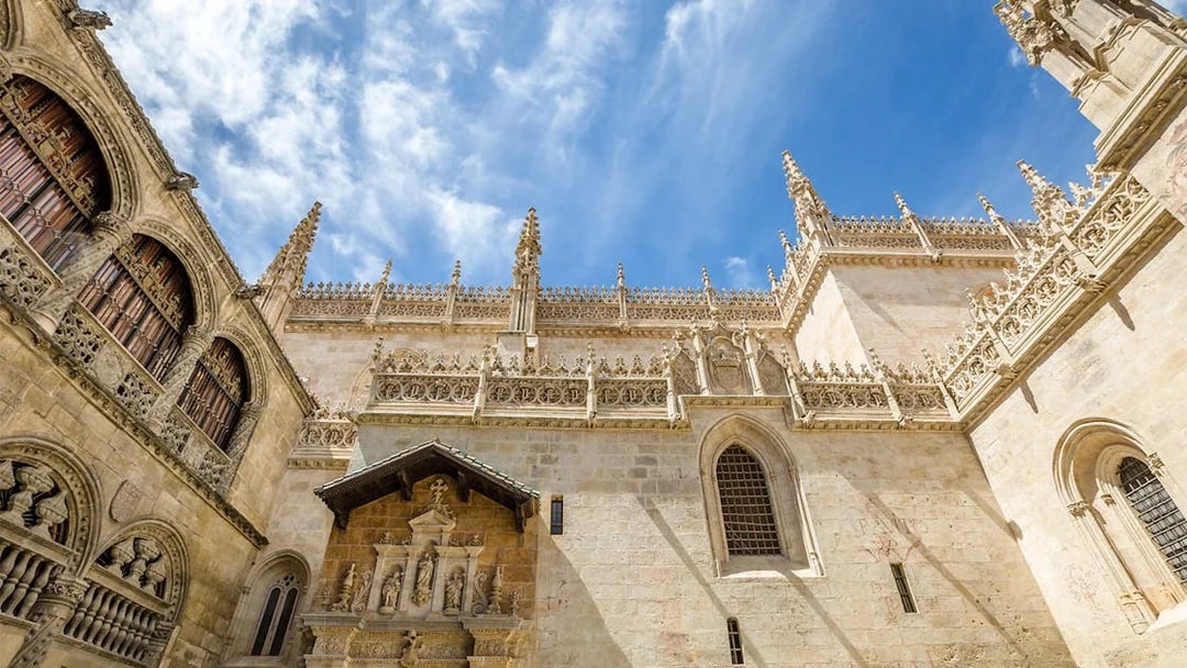 Granada Royal Chapel exterior with ornate Gothic architecture under a blue sky.