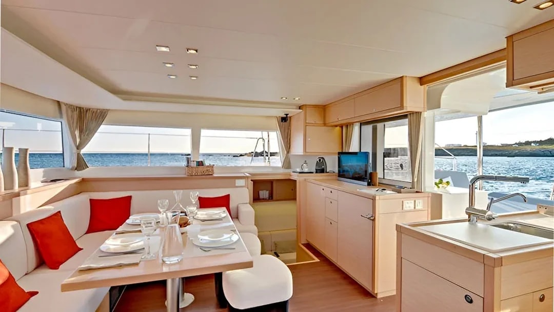 Luxury catamaran interior with dining area and ocean view.