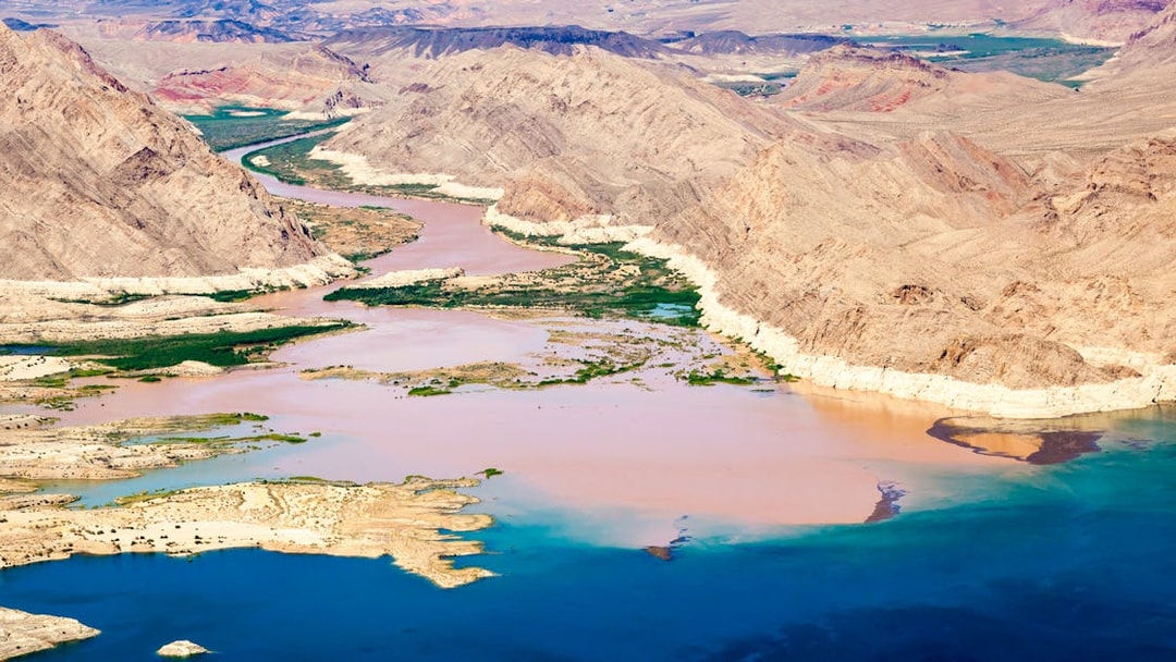 Colorado River flowing into Lake Mead surrounded by desert landscape.