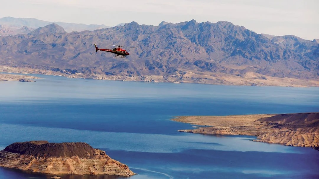 Helicopter flying over Lake Mead with mountains in the background during Las Vegas Strip and Hoover Dam tour.