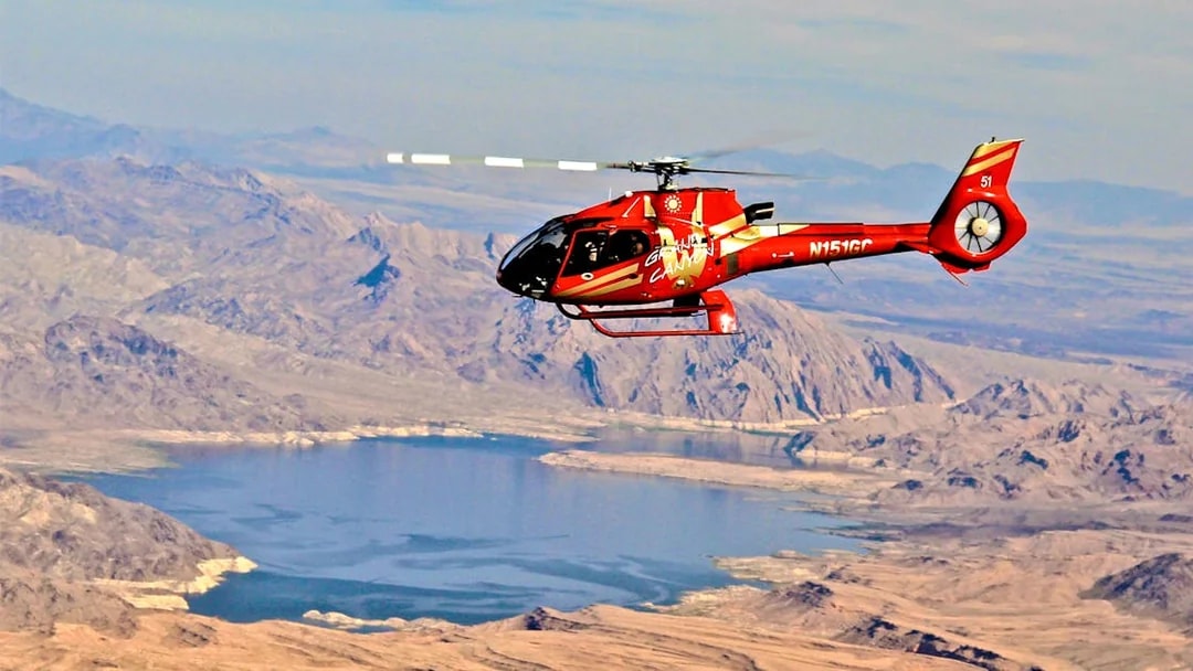 Red Papillon helicopter flying over Lake Mead near the Grand Canyon.