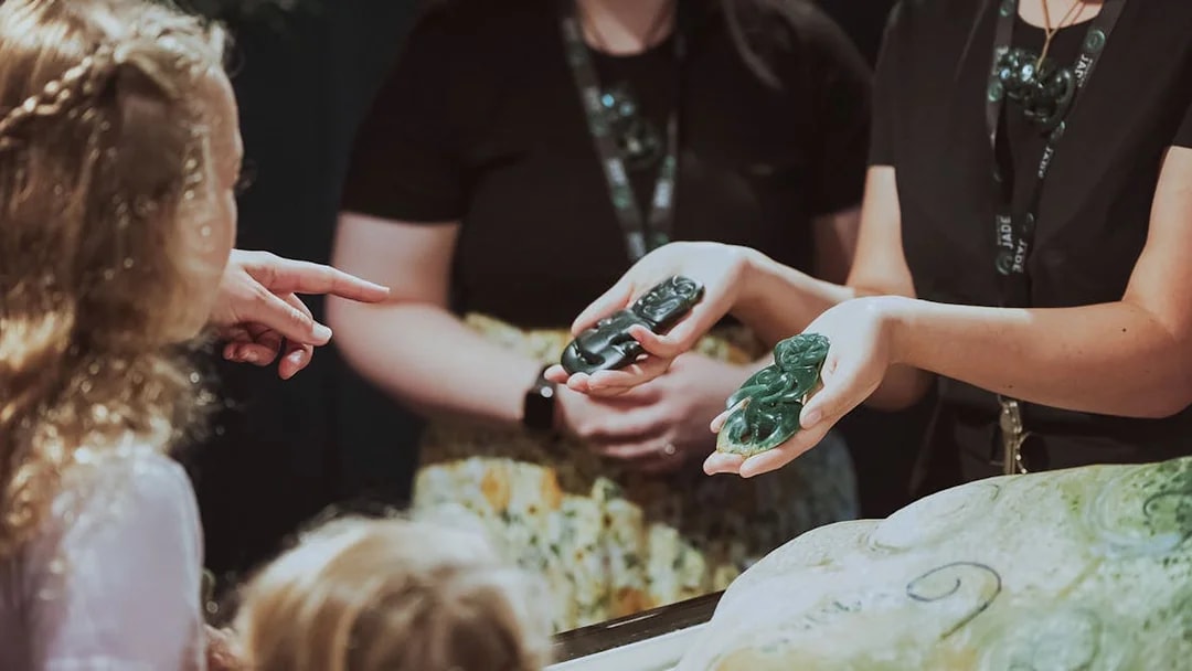 Hands holding jade carvings during Mountain Jade Highlights Tour.