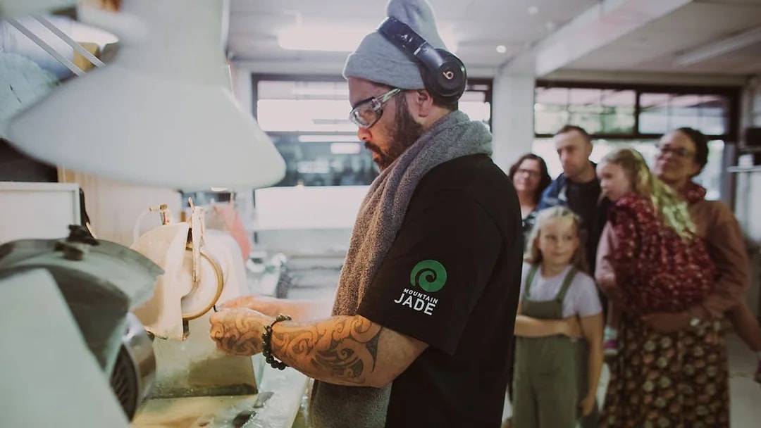 Artisan crafting jade with a group observing during the Mountain Jade Highlights Tour.