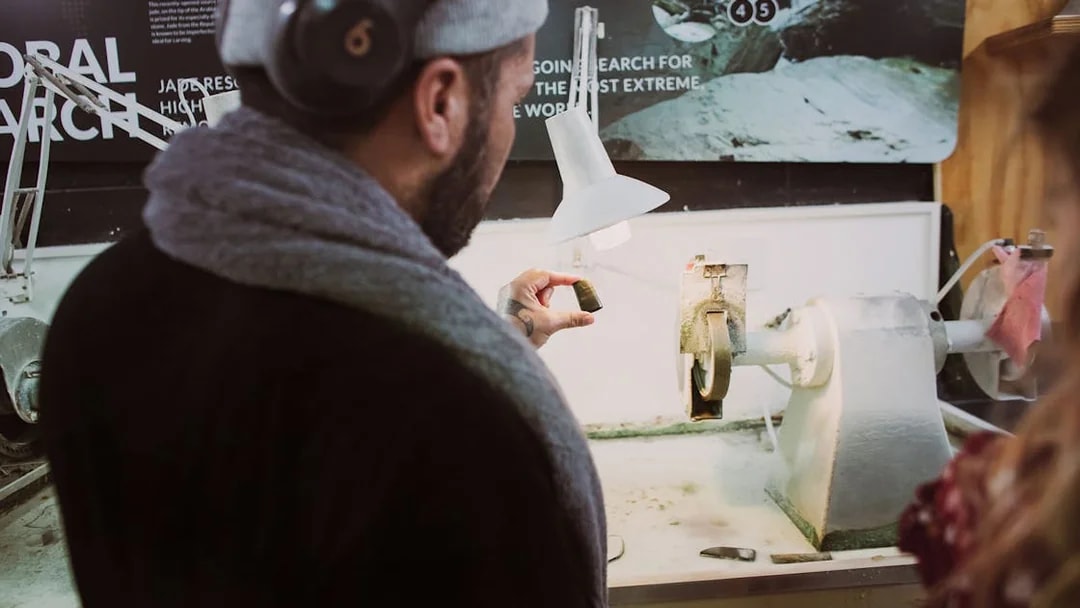 Person examining jade piece during Mountain Jade Highlights Tour.