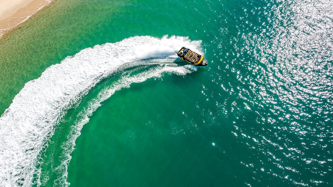 Jet boat making a sharp turn on turquoise waters of Gold Coast.