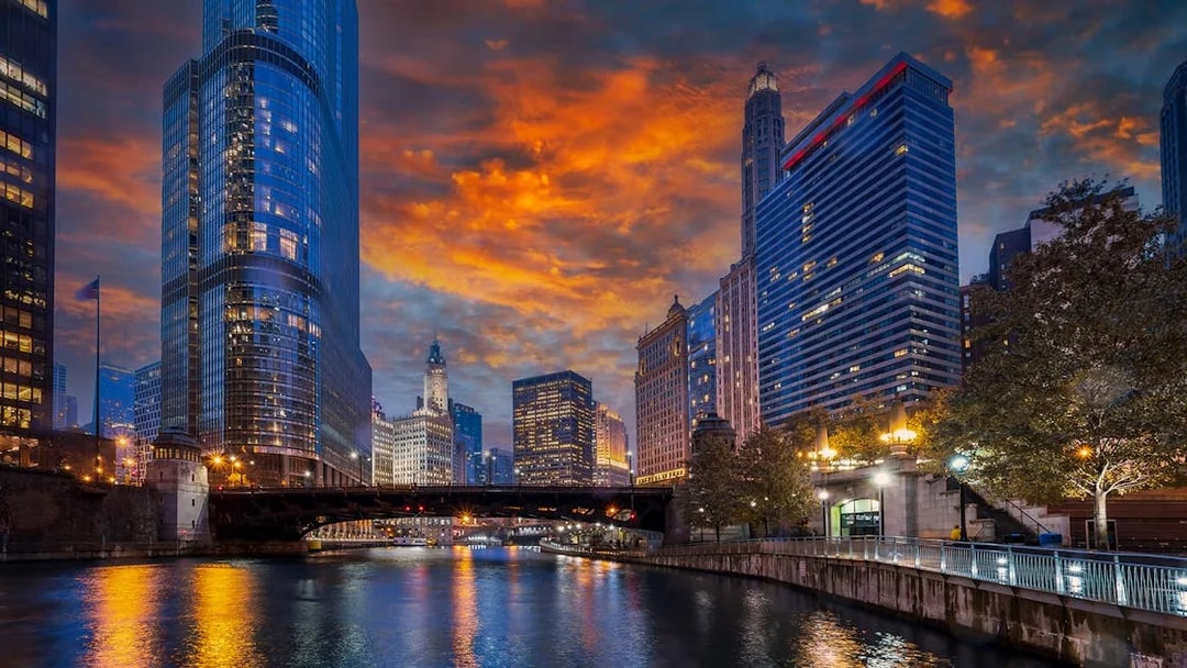 Chicago River with skyscrapers and bridge at sunset during architecture cruise.