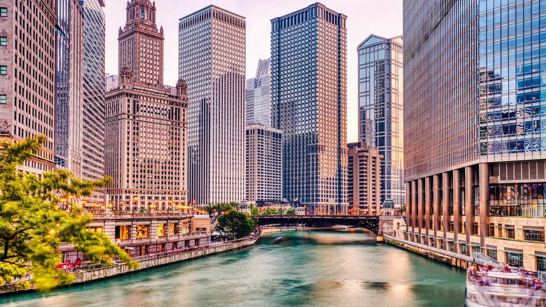 Chicago River with skyscrapers at sunset during architecture cruise.