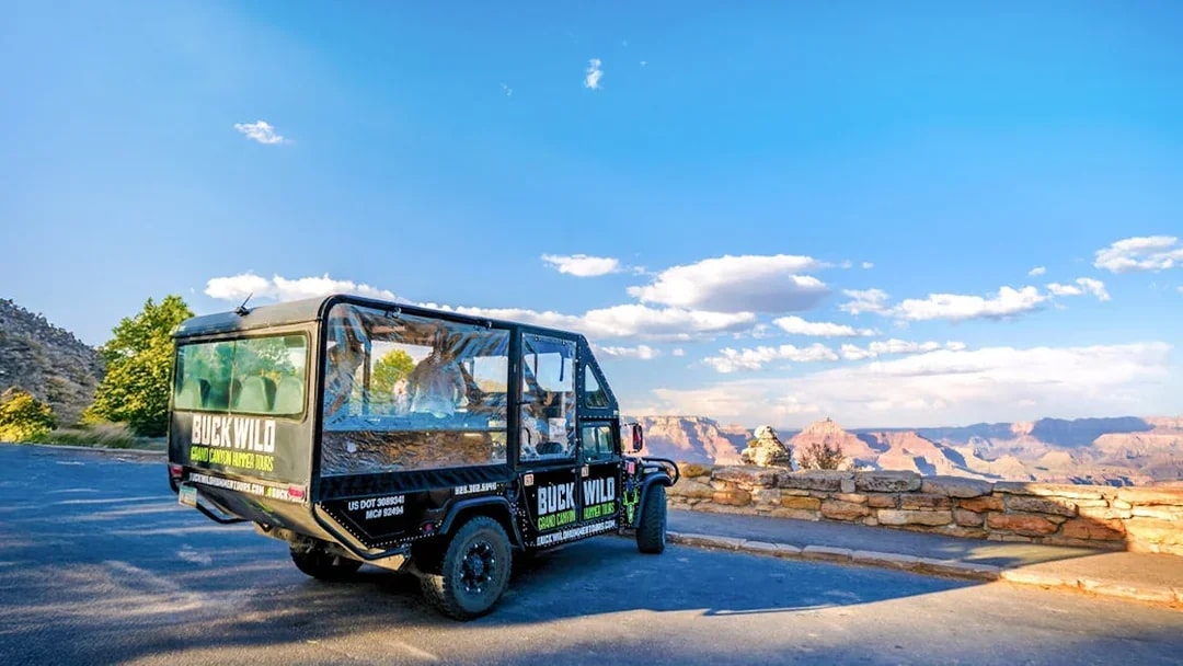 Hummer parked at Grand Canyon viewpoint with scenic canyon backdrop.