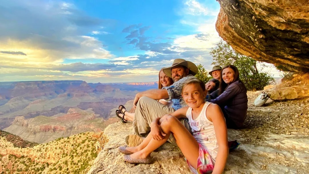 Guests seated on a cliff edge, viewing the Grand Canyon South Rim during a 45-minute airplane tour.