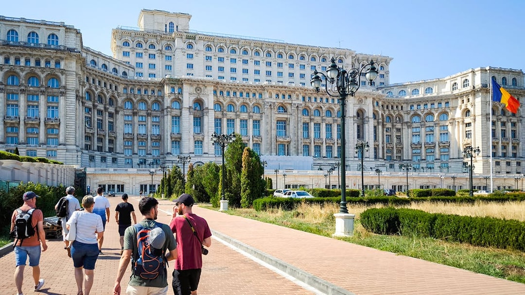 Visitors walking outside the Palace of Parliament in Bucharest, Romania.