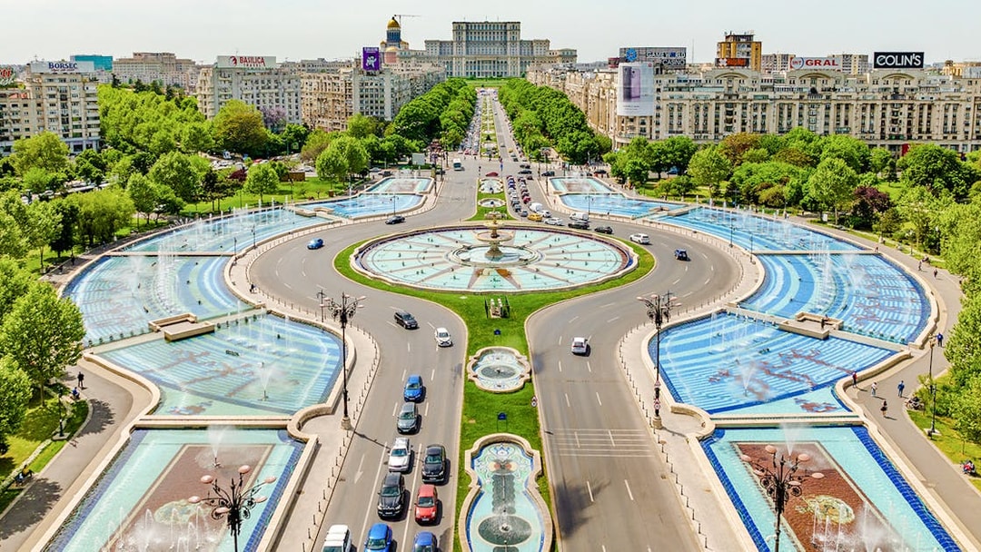 Aerial view of Unirii Square fountains and traffic in Bucharest, Romania.