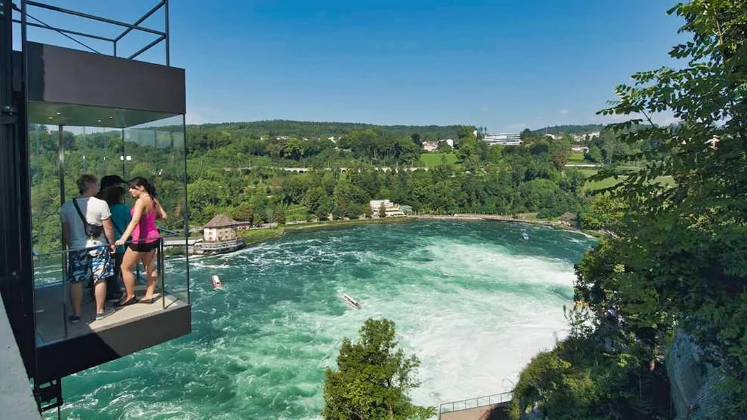 Visitors on a viewing platform overlooking Rhine Falls near Laufen Castle, Switzerland.