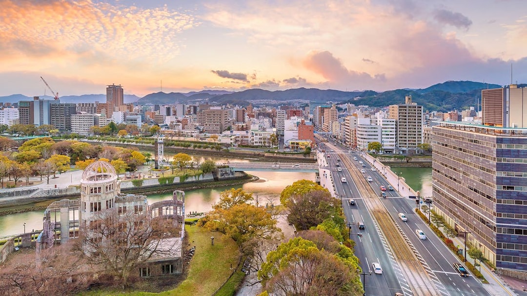 Hiroshima cityscape with Atomic Bomb Dome and Motoyasu River at sunset.