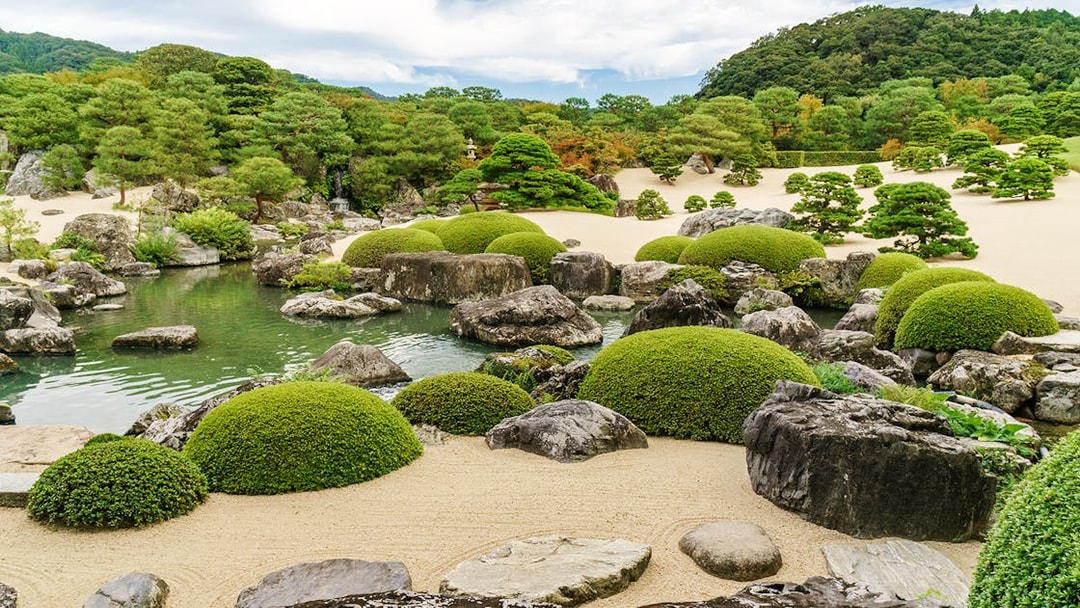 Japanese garden with manicured shrubs, rocks, and a pond in the Sanyo-San'in area.