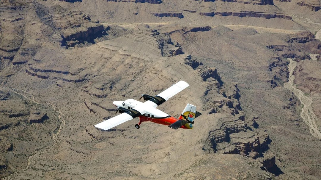 Plane flying over the Grand Canyon's rugged landscape.