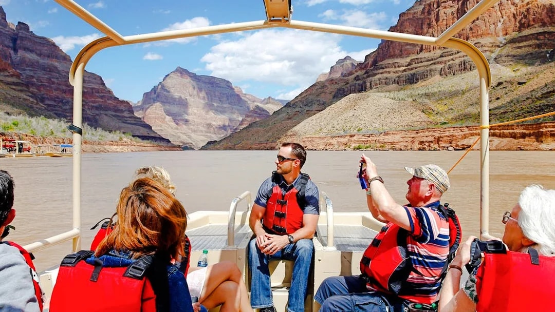 Guests on a boat tour at Grand Canyon West Rim with scenic views of canyon walls.