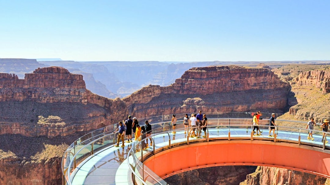 Grand Canyon Skywalk with visitors on glass bridge overlooking canyon.