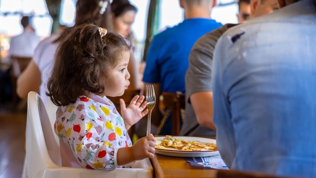 Child enjoying pancakes on a Rotterdam cruise.