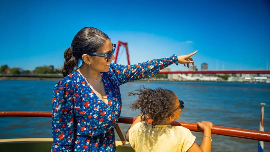 Guests enjoying the view from the Pancake Cruise in Rotterdam, with a bridge in the background.