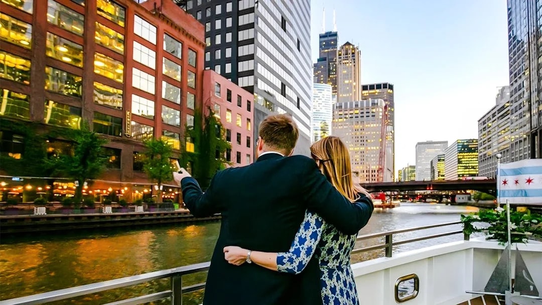 Couple on deck enjoying Chicago skyline during 90-minute scenic sunset Lake Michigan cruise.