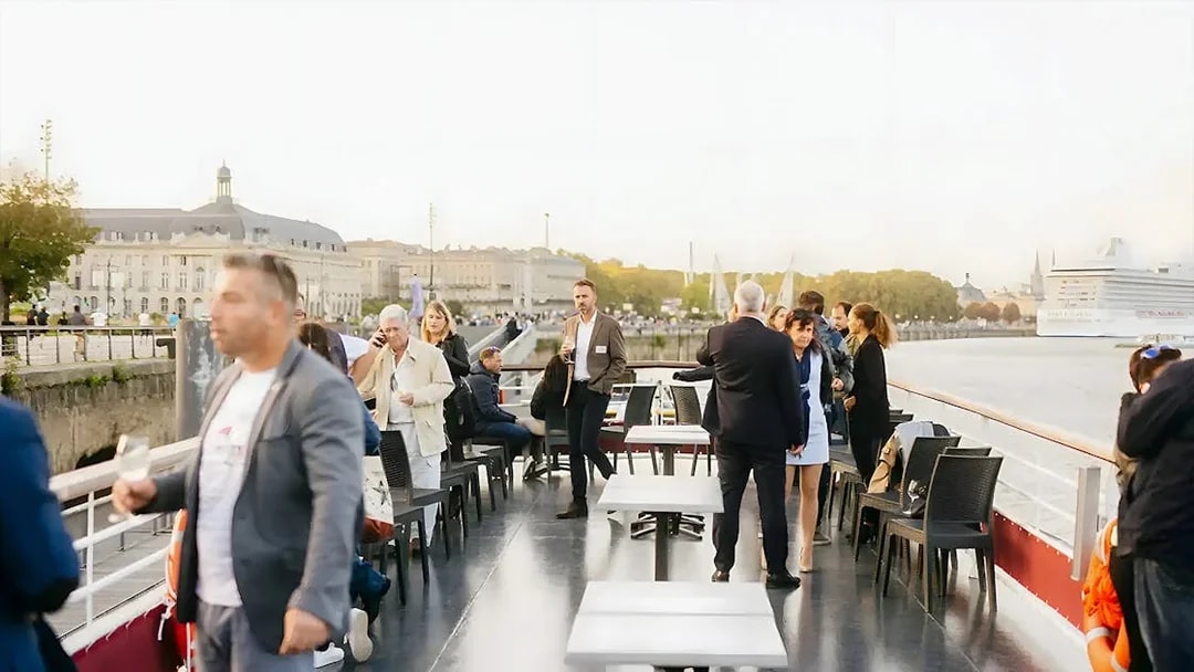 People enjoying wine tasting on a Bordeaux River Cruise deck.